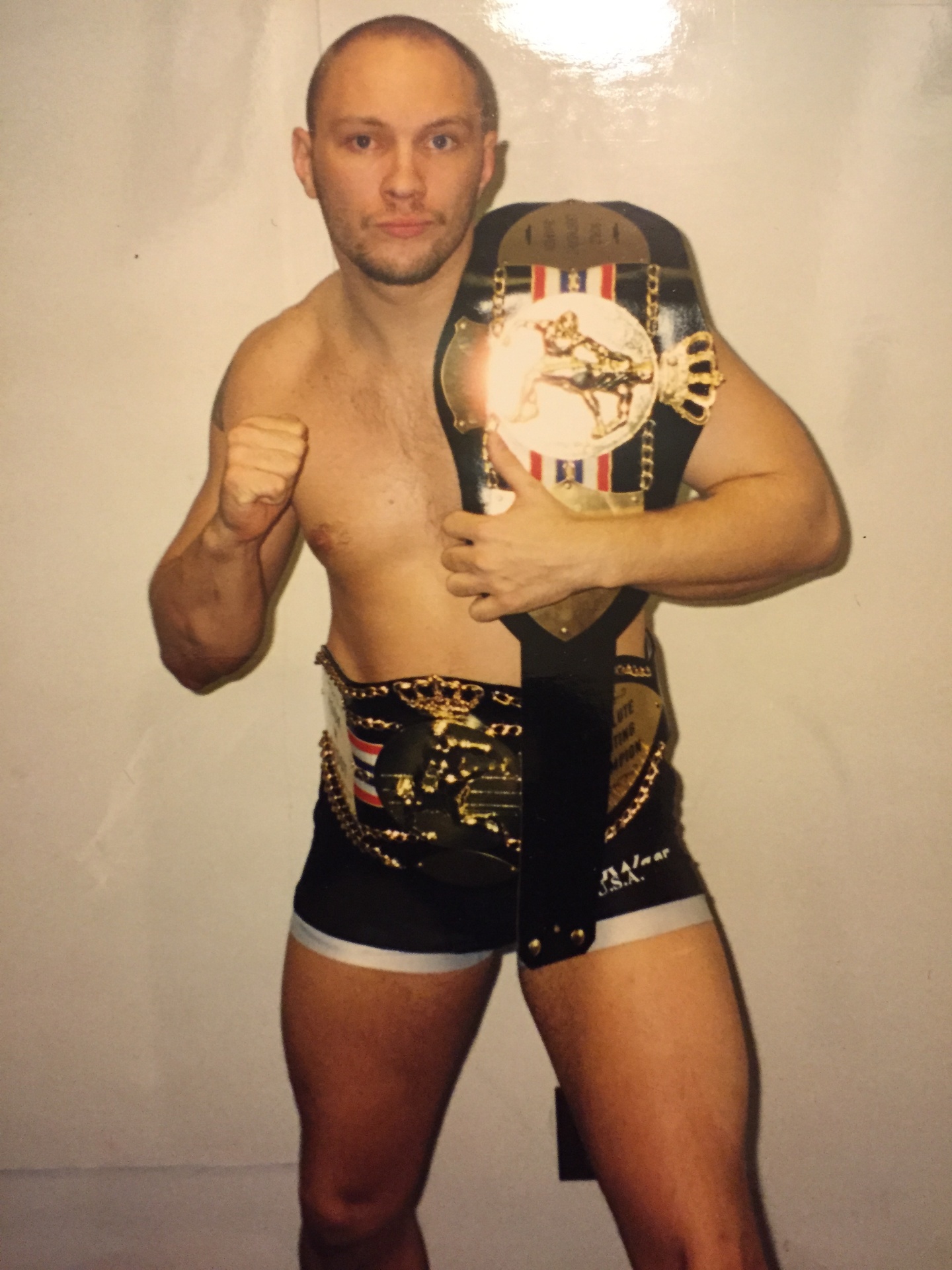 John Renken posing with two MMA championship belts