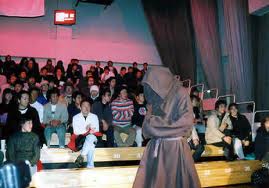 John Renken in friar's robe walking into the arena